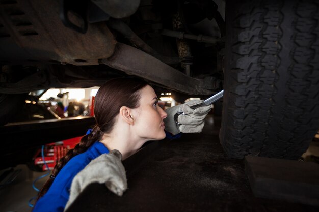 Female mechanic servicing a car