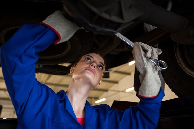 Female mechanic servicing a car