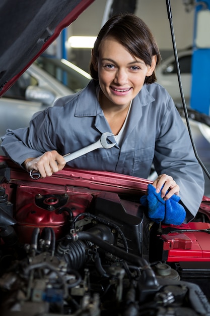 Female mechanic servicing car