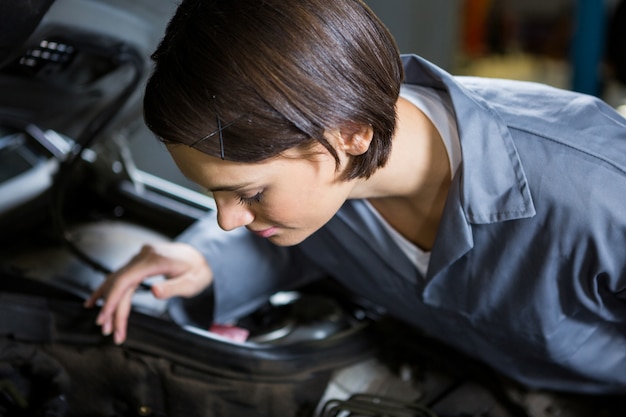 Female mechanic servicing car