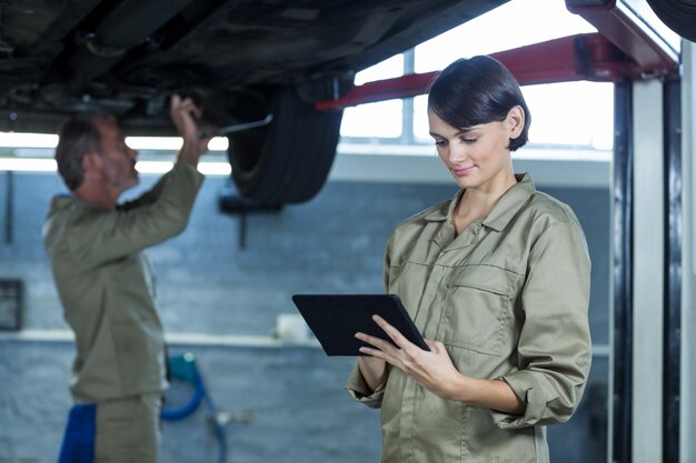 Female mechanic using digital tablet
