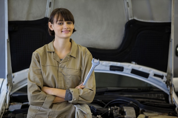 Female mechanic with arms crossed and spanner