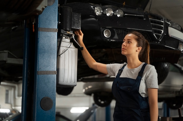 Female mechanic working in the shop on a car