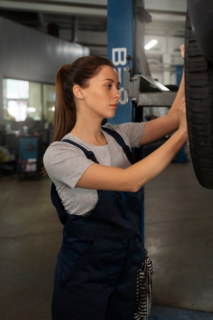 Female mechanic working in the shop on a car