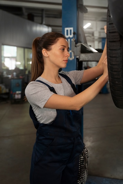 female mechanic working in the shop on a car