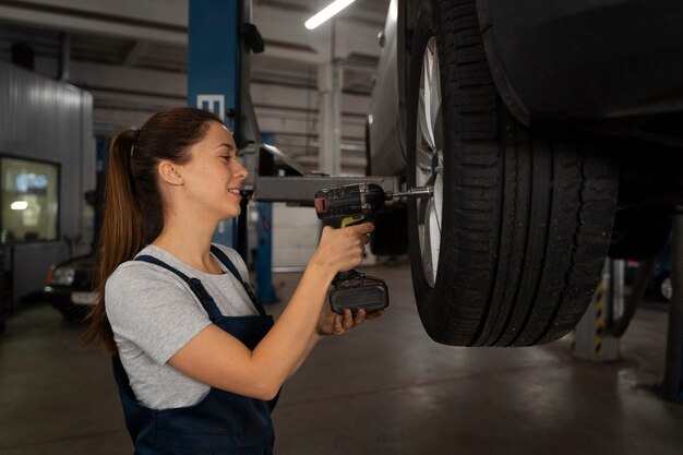 female mechanic working in the shop on a car