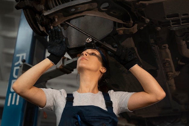 Female mechanic working in the shop on a car