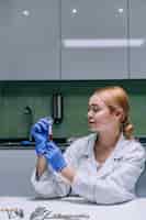 Foto gratuita ricercatore medico o scientifico femminile che esamina una provetta in un laboratorio.