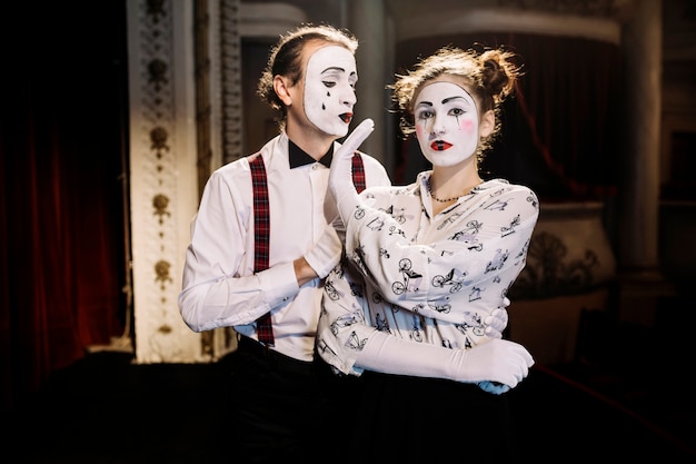 Female mime showing no hand sign to male mime