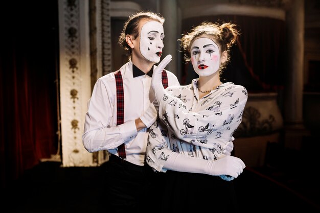 Female mime showing no hand sign to male mime