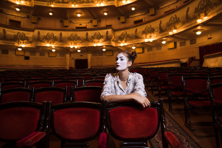 Free Photo female mime sitting on chair