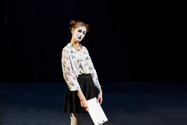 Female mime with manuscript looking at camera