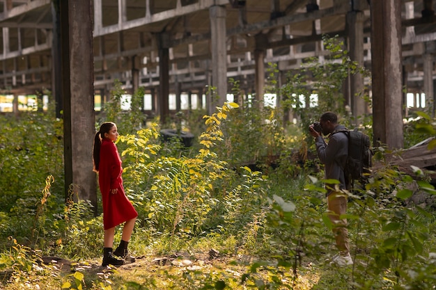 Free photo female model being photographed with grunge environment during urban exploration