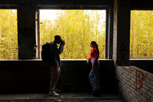 Free photo female model being photographed with grunge environment during urban exploration