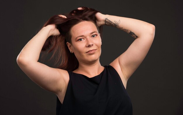 Female model in black shirt promoting hairstyle.