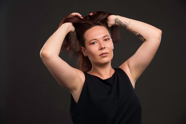 Female model in black shirt promoting hairstyle. 