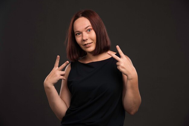 Female model in black shirt sending peace message.