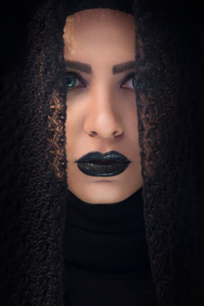 Female model in gothic lace shawl and purple lipstick