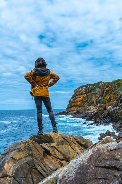 美しい海に満足して見ている女性モデル