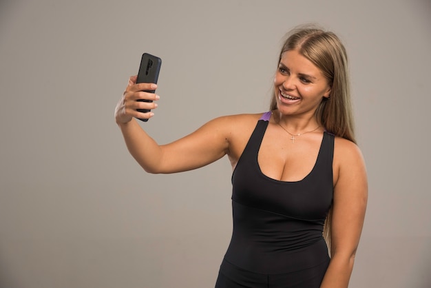 Free photo female model in sport bra taking her selfie.