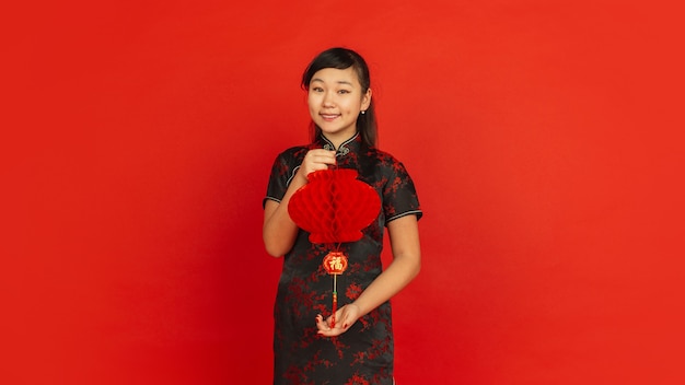 Female model in traditional clothes looks happy and smiling with decoration