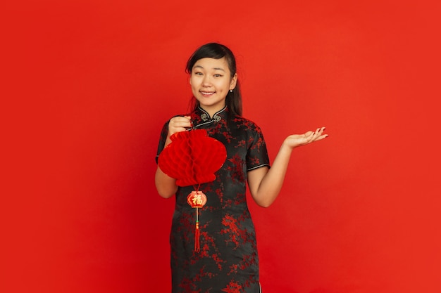 Female model in traditional clothes looks happy and smiling with decoration