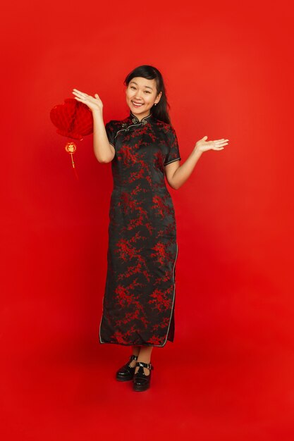 Female model in traditional clothes looks happy and smiling with decoration