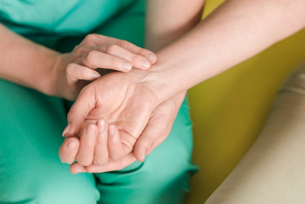 Female nurse checking patient's heartbeat