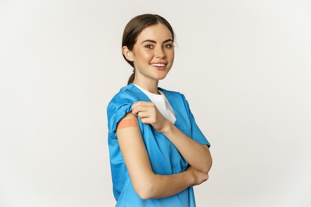 Female nurse doctor medical worker got vaccinated showing shoulder with patch after covid vaccine sm...