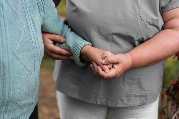 Female nurse helping older woman walk