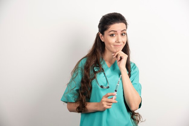 Female nurse with stethoscope holding injection.