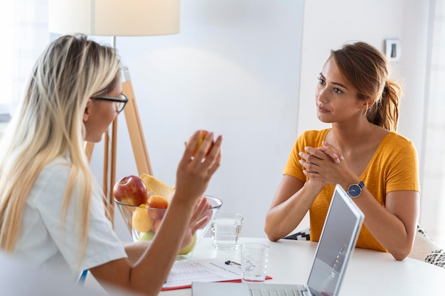 Foto gratuita nutrizionista femminile che dà consulenza al paziente fare un programma di dieta nella clinica di perdita di peso