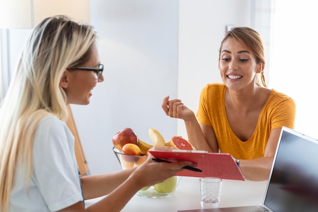 Female nutritionist giving consultation to patient Making diet plan in weight loss clinic