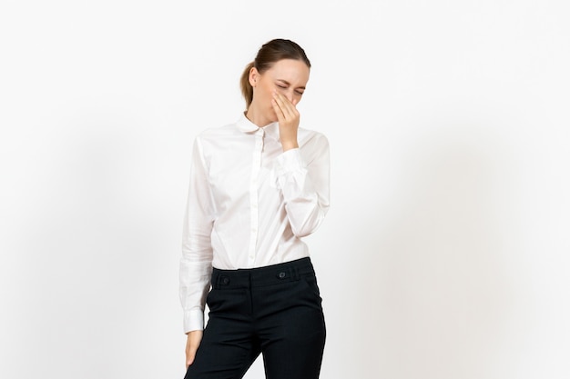 female office employee in elegant white blouse covering her nose on white