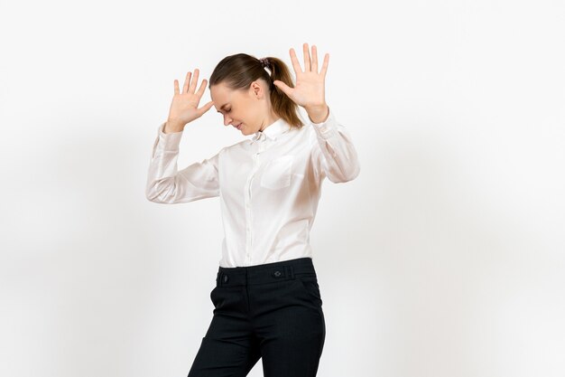 female office employee in elegant white blouse with scared gestures on white