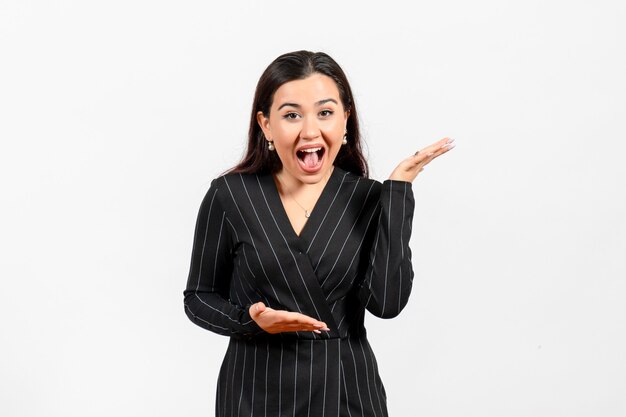 female office employee in strict black suit emotionally posing on white