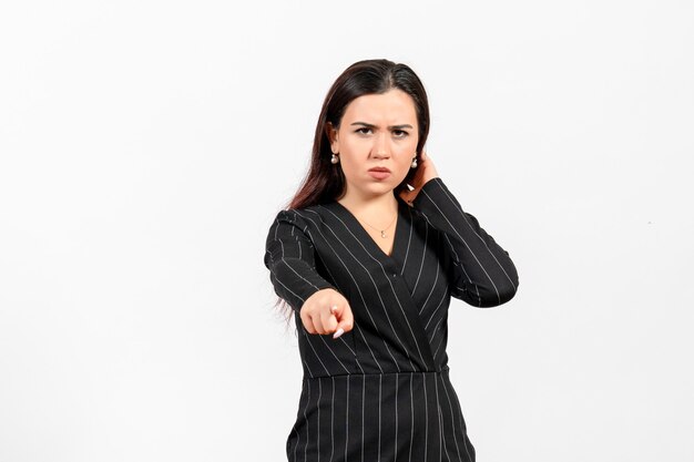 female office employee in strict black suit pointing on white