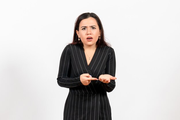 female office employee in strict black suit posing on light white