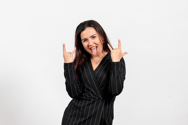 female office employee in strict black suit posing in rocker manner on white