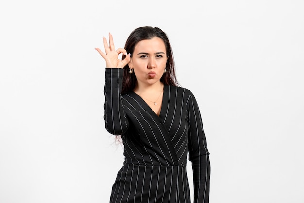 female office employee in strict black suit posing on white