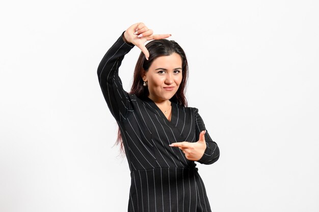 female office employee in strict black suit posing on white