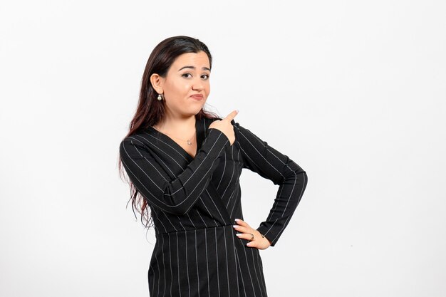 female office employee in strict black suit posing on white