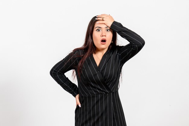 female office employee in strict black suit posing with shocked face on white