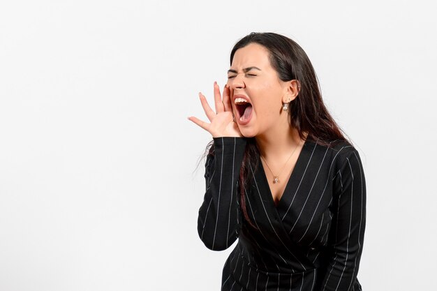 female office employee in strict black suit screaming on white