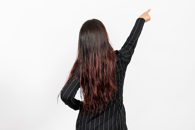 female office employee in strict black suit turning her back and pointing on white