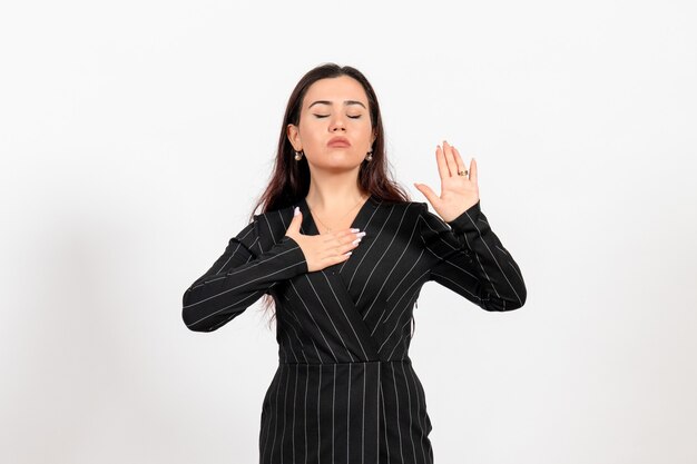 female office employee in strict black suit with closed eyes on white