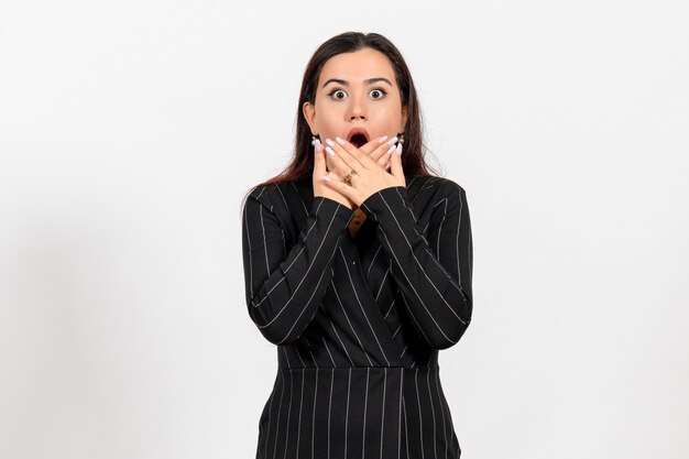 female office employee in strict black suit with shocked face on white