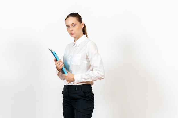 female office employee in white blouse holding documents on white