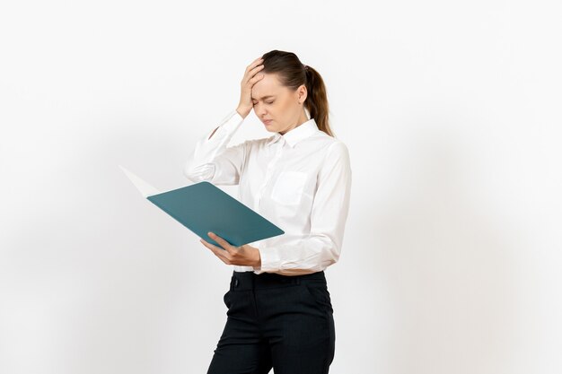 female office employee in white blouse holding and reading blue file on white