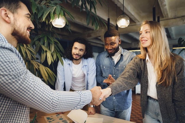 Free photo female office executive shaking hand of new male team member employee